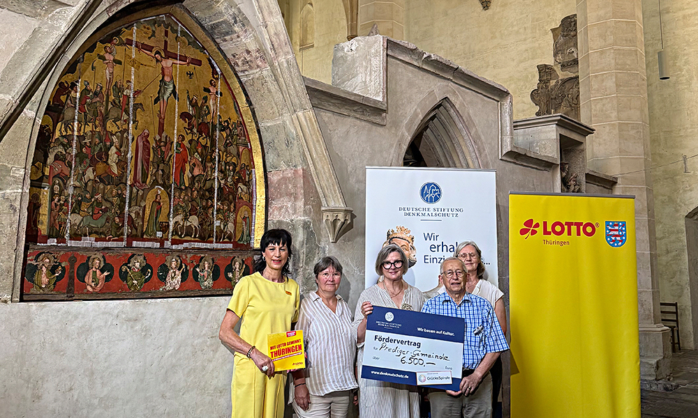 Übergabe des Fördermittelschecks an die Pfarrerin der Predigerkirche vor dem beeindruckenden Tafelbild